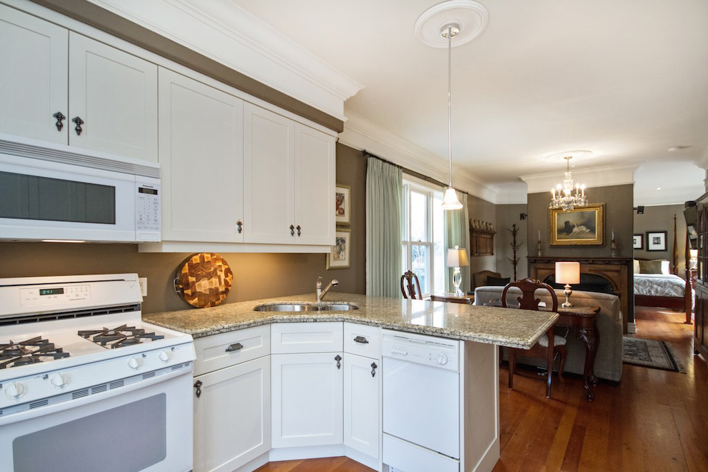 Inside suite 5 of the Gingerbread House, Burlington with kitchen, fireplace and 4 poster bed.